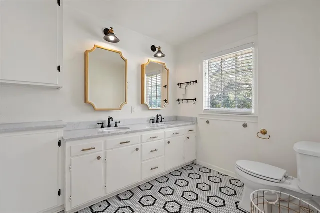 a bathroom with a toilet a sink a mirror a and a window