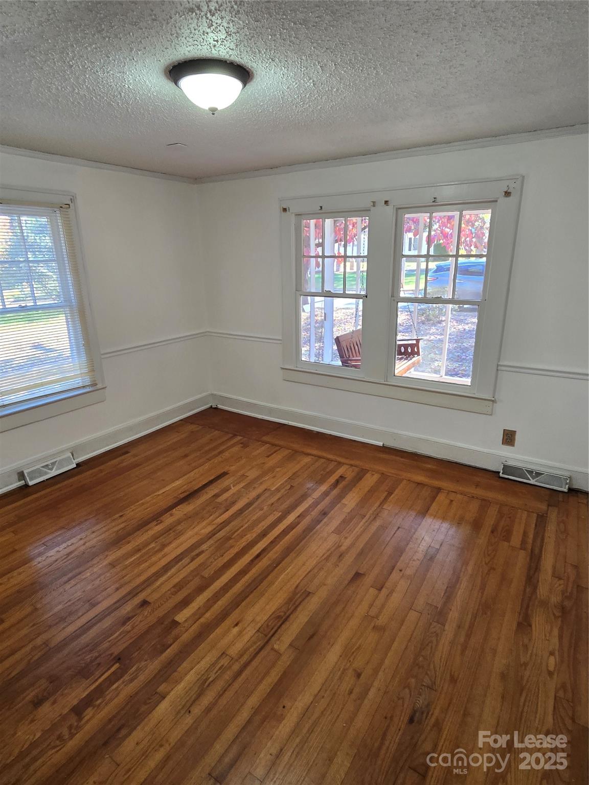 1233 East Cannon Avenue Albemarle, NC 28001 - Photo 3 of 13 an empty room with wooden floor and windows