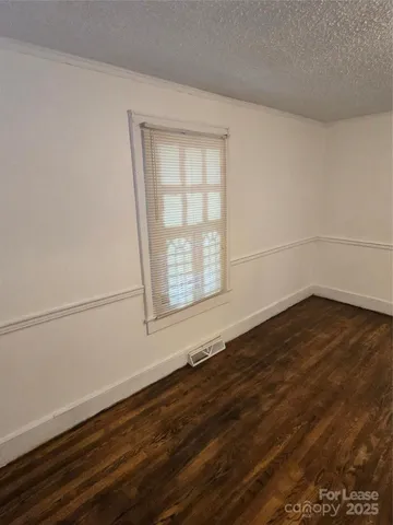 a view of a room that has wooden floor and more window