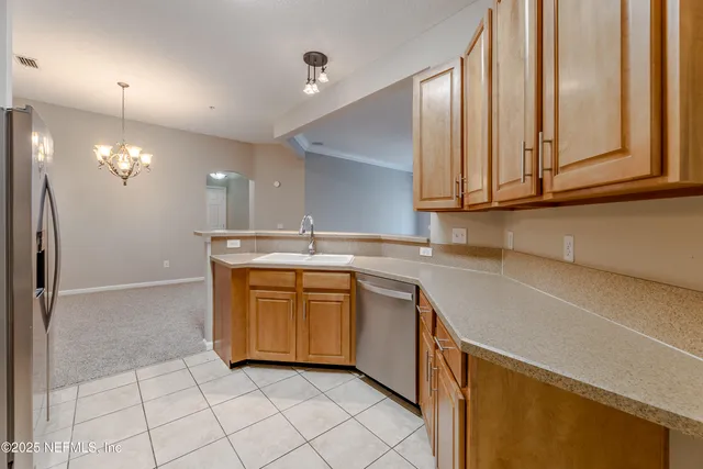 a kitchen with stainless steel appliances granite countertop a sink and a refrigerator