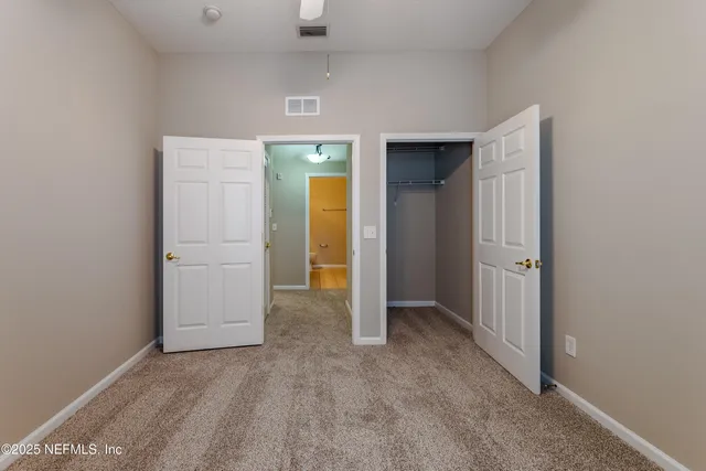 an empty room with closet and mirror