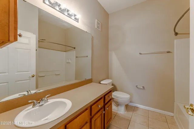 a bathroom with a granite countertop sink toilet a mirror and shower