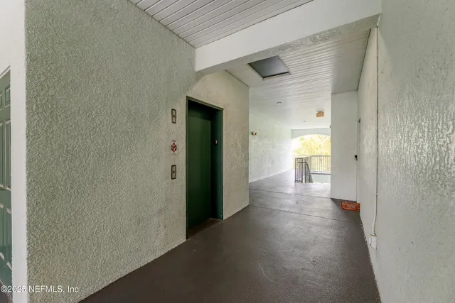 a view of a hallway with wooden shelves