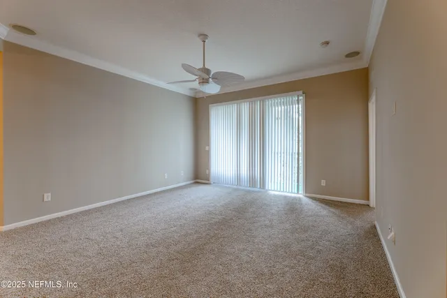 en empty room with windows and ceiling fan