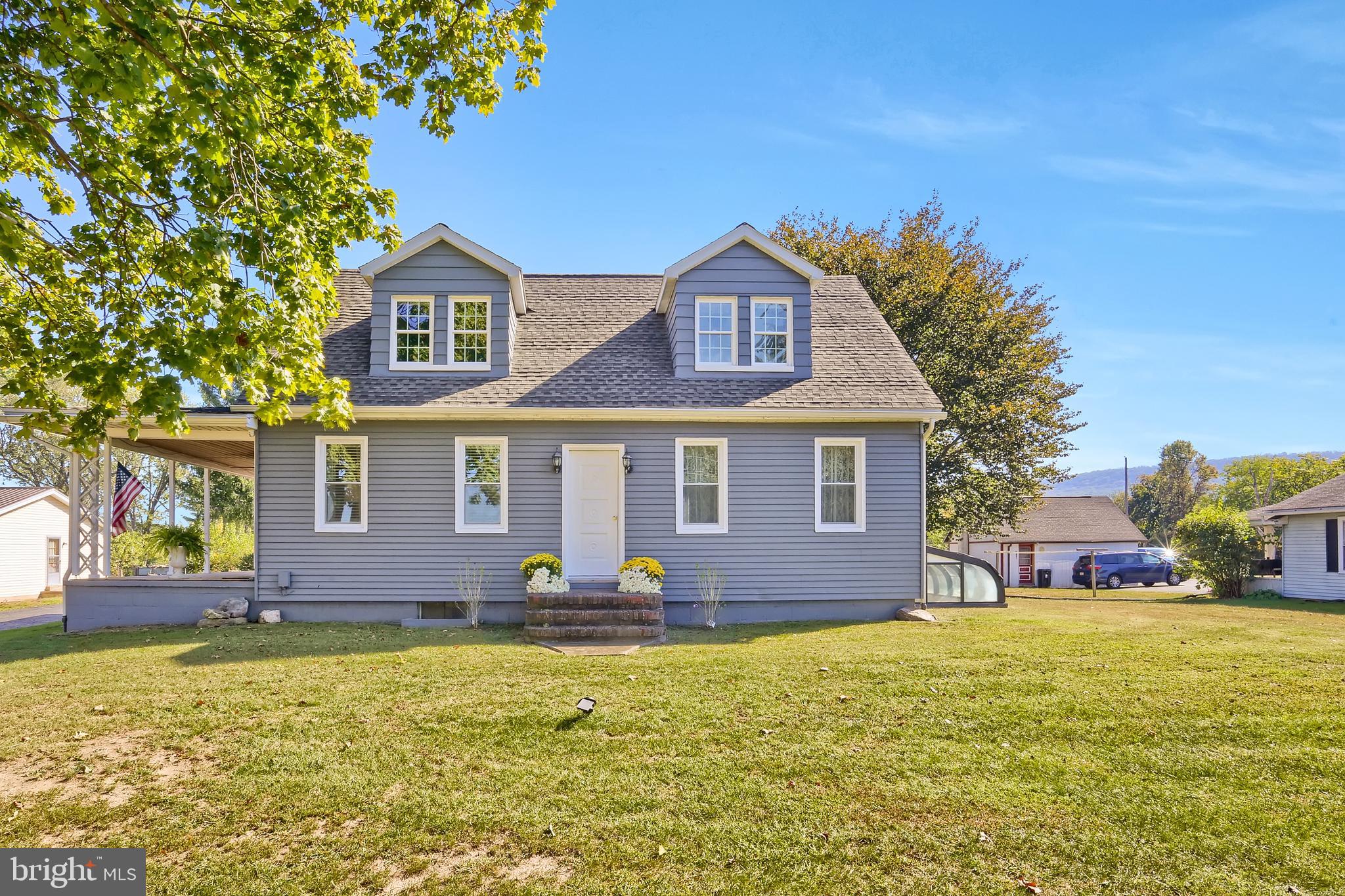 a front view of house with yard and trees in the background