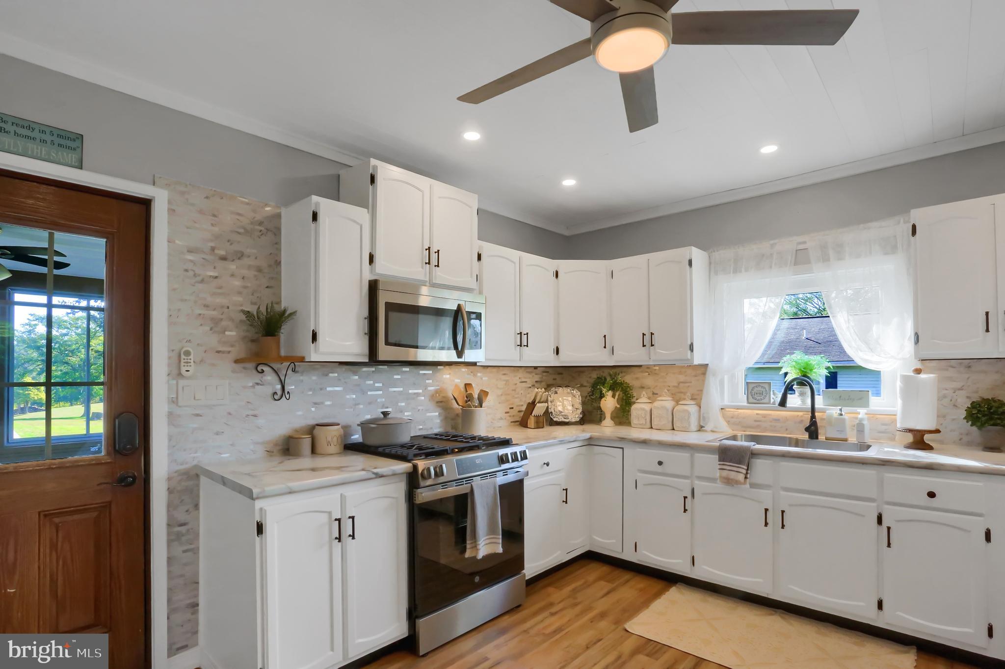 3209 Peters Mountain Road Halifax, PA 17032 - Photo 12 of 56 a kitchen with granite countertop a sink stainless steel appliances and white cabinets