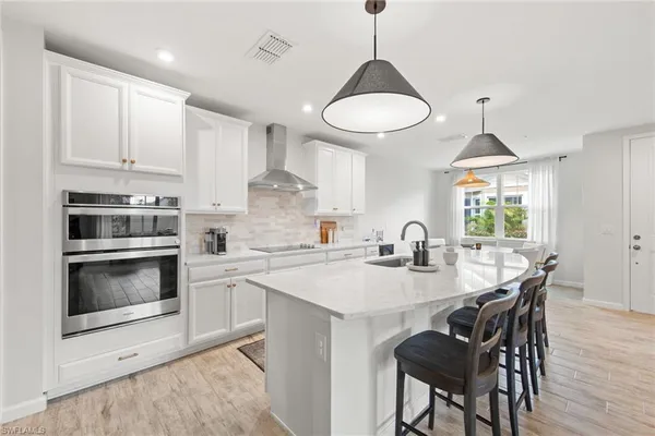 a kitchen with stainless steel appliances granite countertop a stove a sink a microwave a dining table and chairs