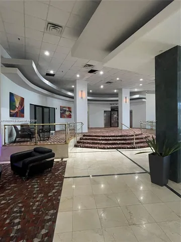 a lobby with a couch and a potted plant