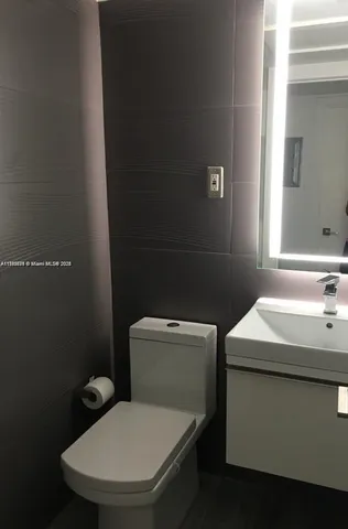 a white toilet sitting next to a bathroom sink