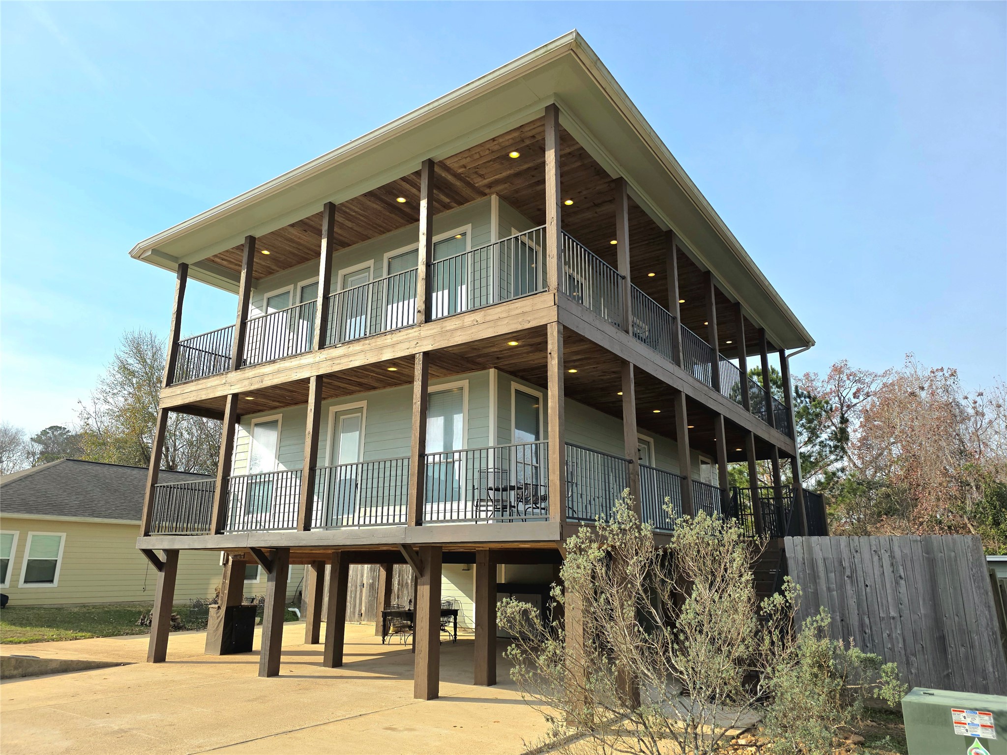 This photo featuring a beautiful 3 story waterview home with lot of custom touches, including 2 large wrap around decks, tongue and grove ceilings and recessed lighting. Lots of lake views from every spot.