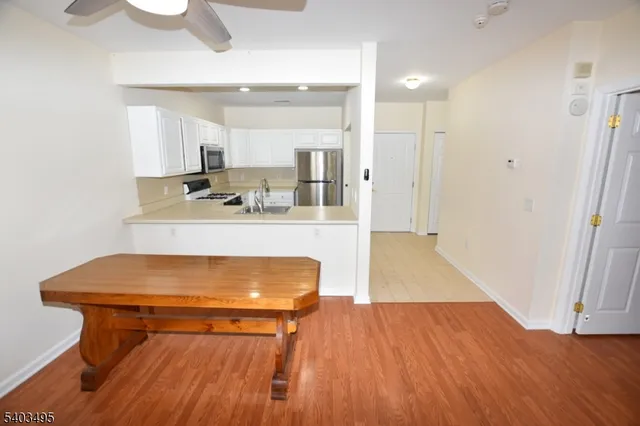 a room with wooden floor table and chairs