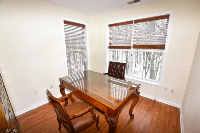 a view of a workspace with furniture and a window