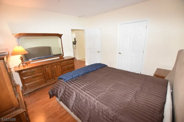 a bedroom with a bed and a flat tv screen on a dresser