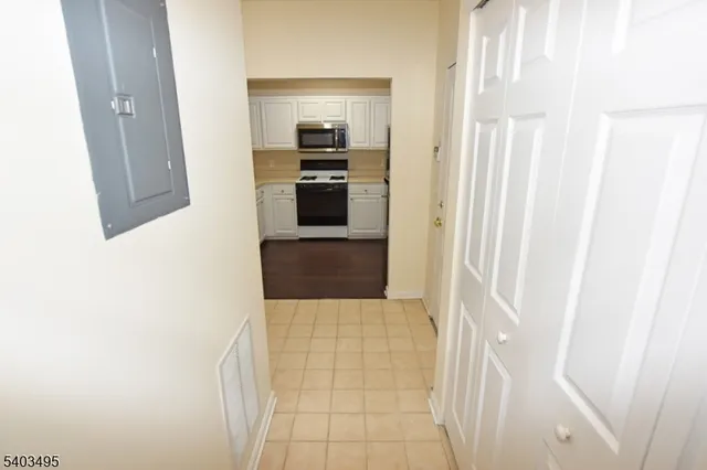 a kitchen with white cabinets and stainless steel appliances