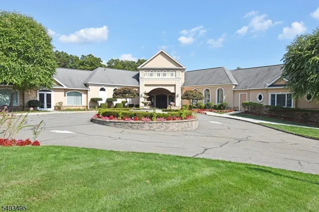 a front view of a house with a yard and potted plants