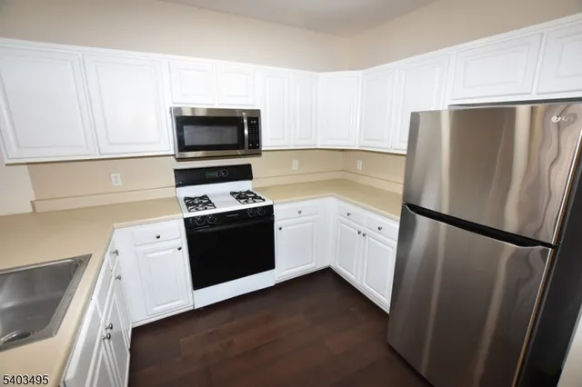 a kitchen with a refrigerator stove and white cabinets