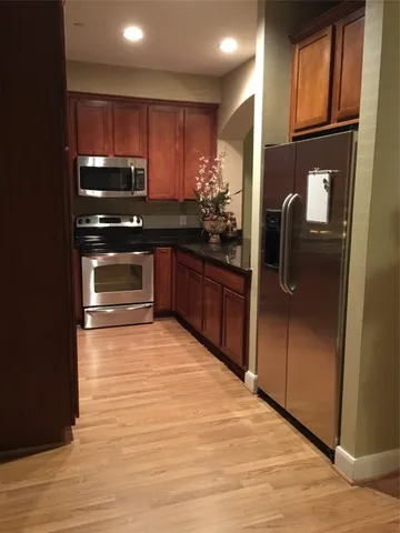 a kitchen with stainless steel appliances granite countertop a refrigerator and a sink