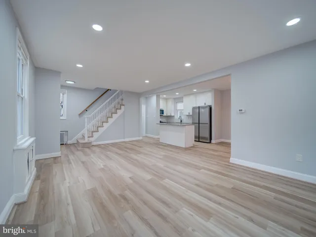 a view of empty room with wooden floor and window