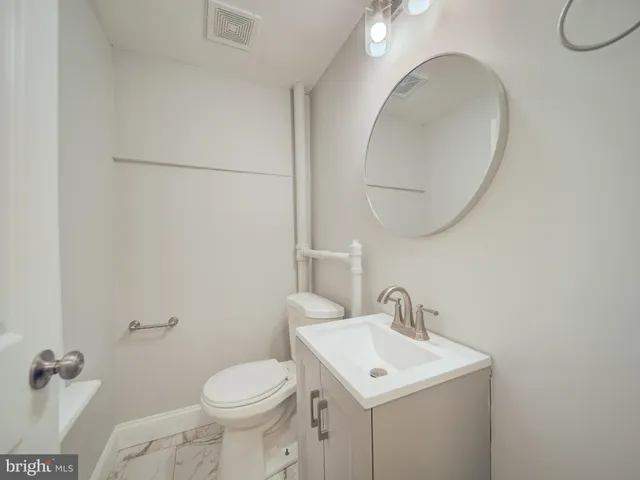 a bathroom with a toilet sink and mirror