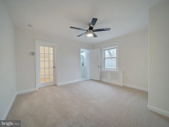 an empty room with closet and windows