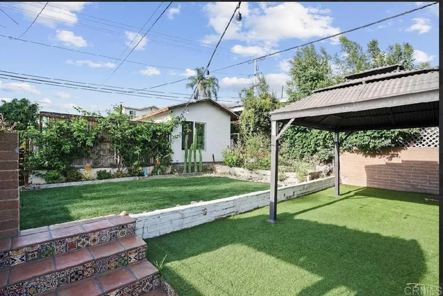 a view of a porch in front of a house with a big yard
