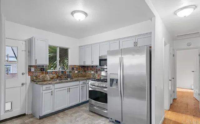 a kitchen with a refrigerator sink and cabinets