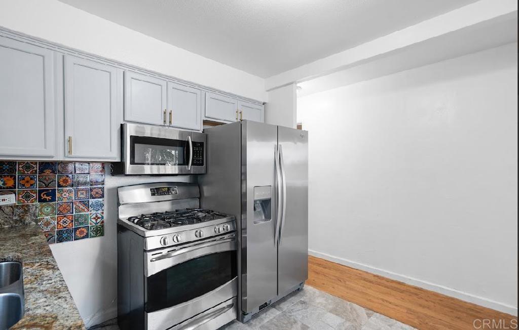 3964 Delta Street San Diego, CA 92113 - Photo 12 of 35 a kitchen with a refrigerator stove and microwave