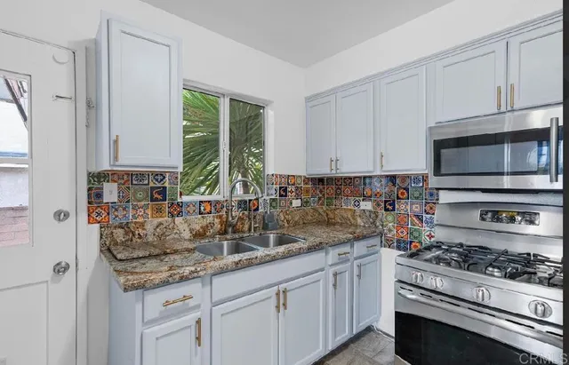 a kitchen with stainless steel appliances granite countertop a sink stove and cabinets