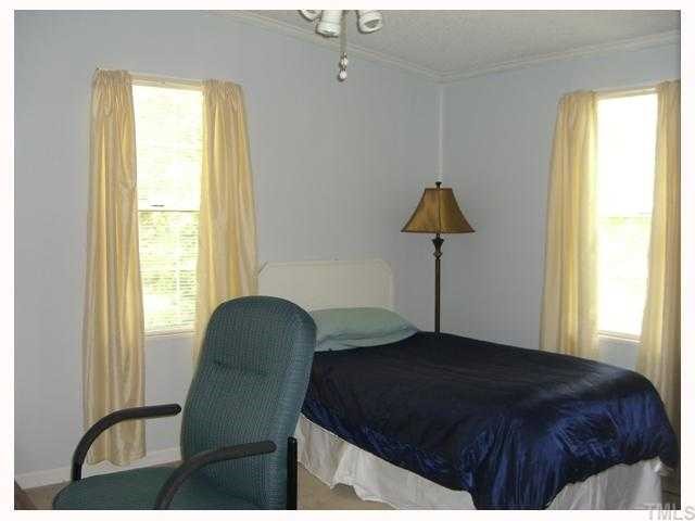 204 Irelan Drive Raleigh, NC 27606 - Photo 4 of 12 a bedroom with a bed and a chair