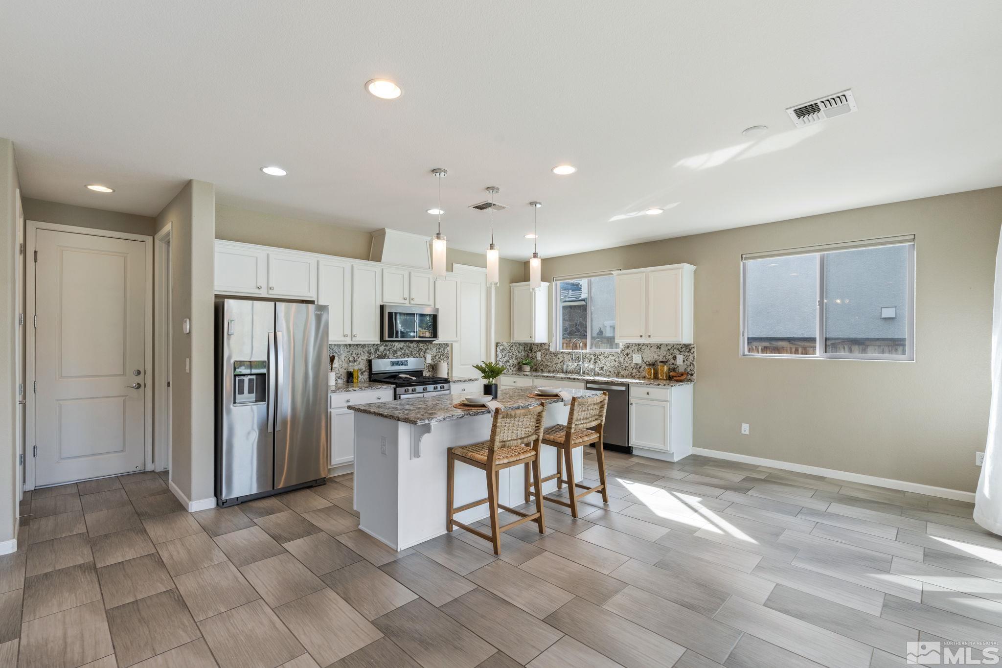 3025 Ethelinda Way Reno, NV 89521 - Photo 7 of 31 a kitchen with a refrigerator and a table