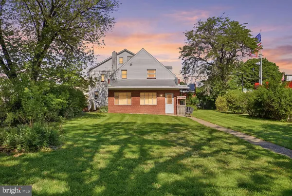 a view of a big yard in front of a house with large trees