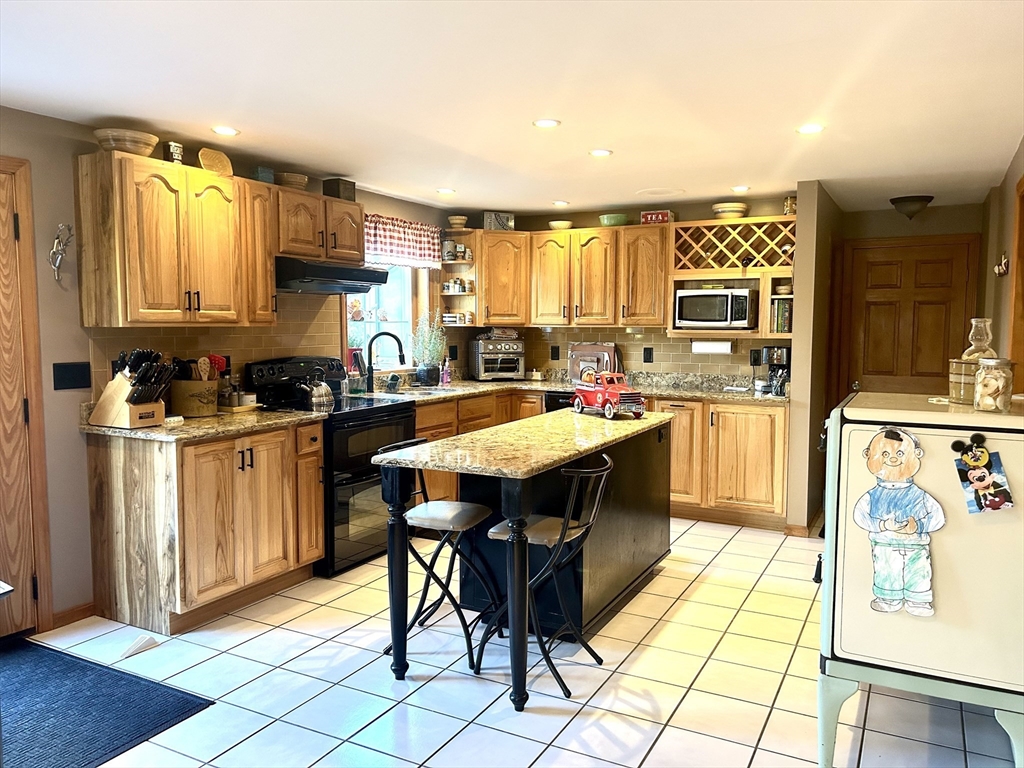43 Boston Hill Road Fairhaven, MA 02719 - Photo 9 of 25 a kitchen with stainless steel appliances granite countertop a stove a sink dishwasher and a refrigerator with wooden cabinets