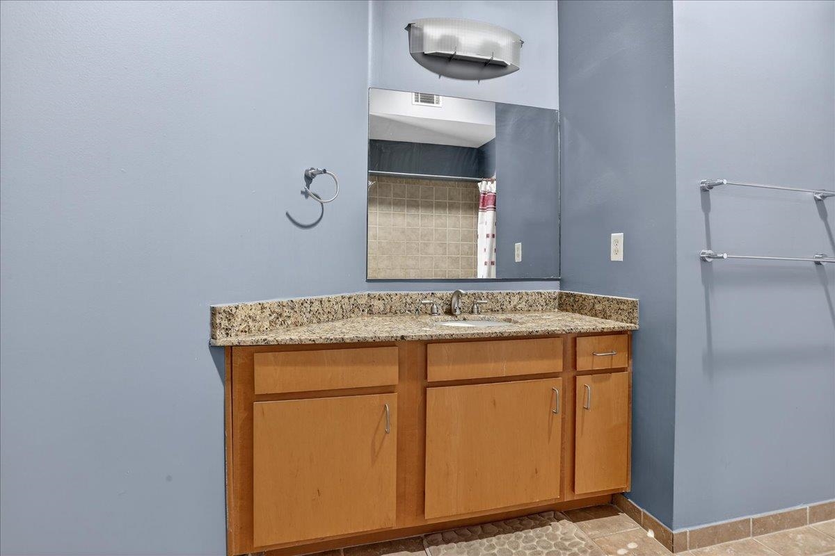440 North Front Street, Unit 202 Memphis, TN 38105 - Photo 17 of 20 a bathroom with a granite countertop sink and a mirror