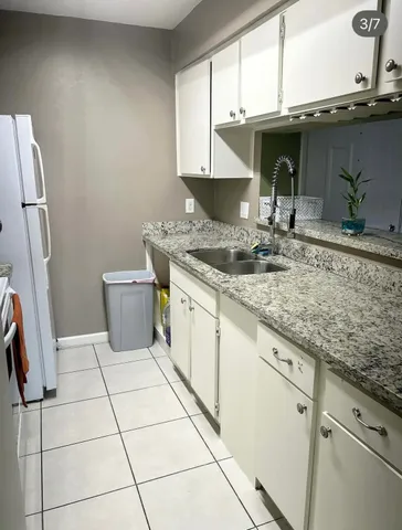 a kitchen with a sink a stove and cabinets