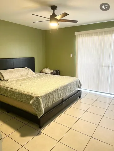 a bedroom with a bed and a chandelier fan