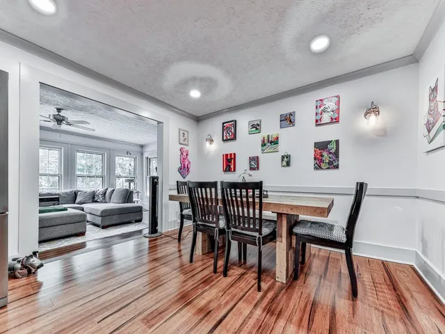 a dining room with furniture wooden floor a rug and a chandelier
