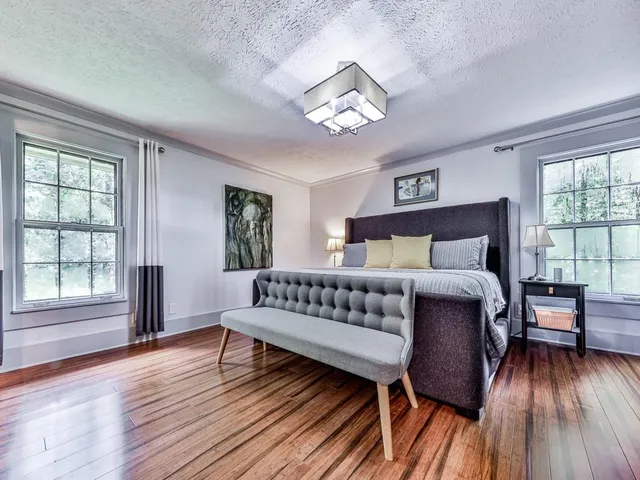 a bedroom with a bed and wooden floor