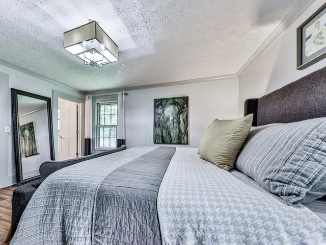 a bedroom with a large bed and a chandelier