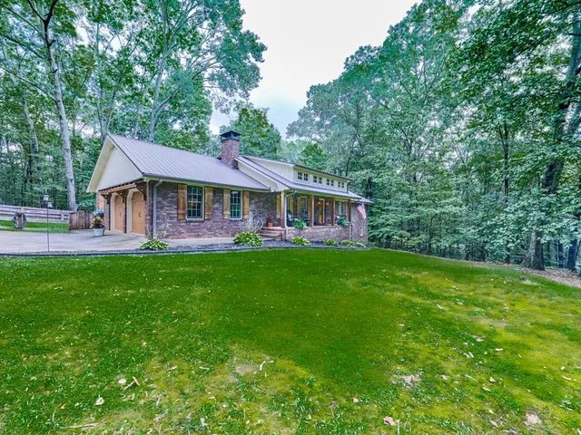 a front view of a house with yard and green space
