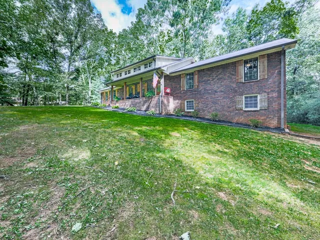 a front view of a house with yard and trees