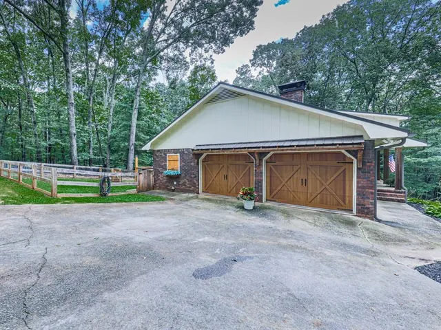 a view of a house with backyard and trees