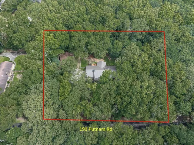 an aerial view of residential house with outdoor space and trees around