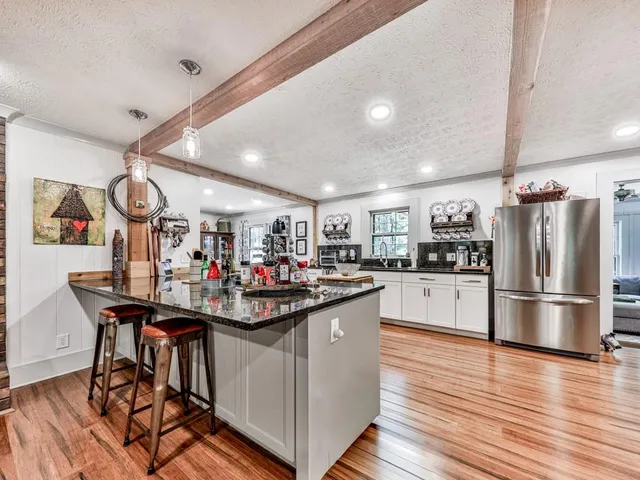 a kitchen with stainless steel appliances granite countertop a sink and a refrigerator