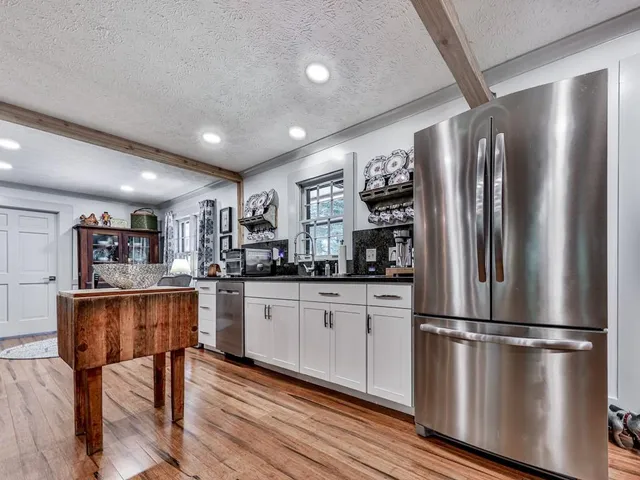 a kitchen with stainless steel appliances granite countertop a refrigerator and a stove top oven