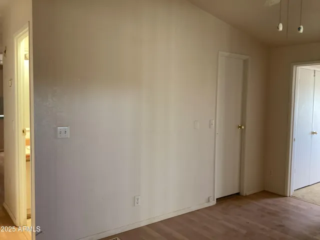 an empty room with a ceiling fan and window