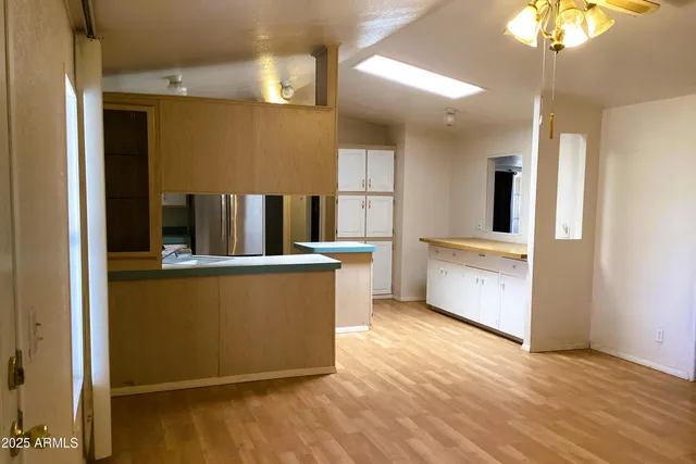 a large kitchen with stainless steel appliances a large counter top a stove and a refrigerator