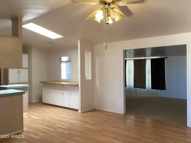 a view of an empty room with wooden floor and a cabinet