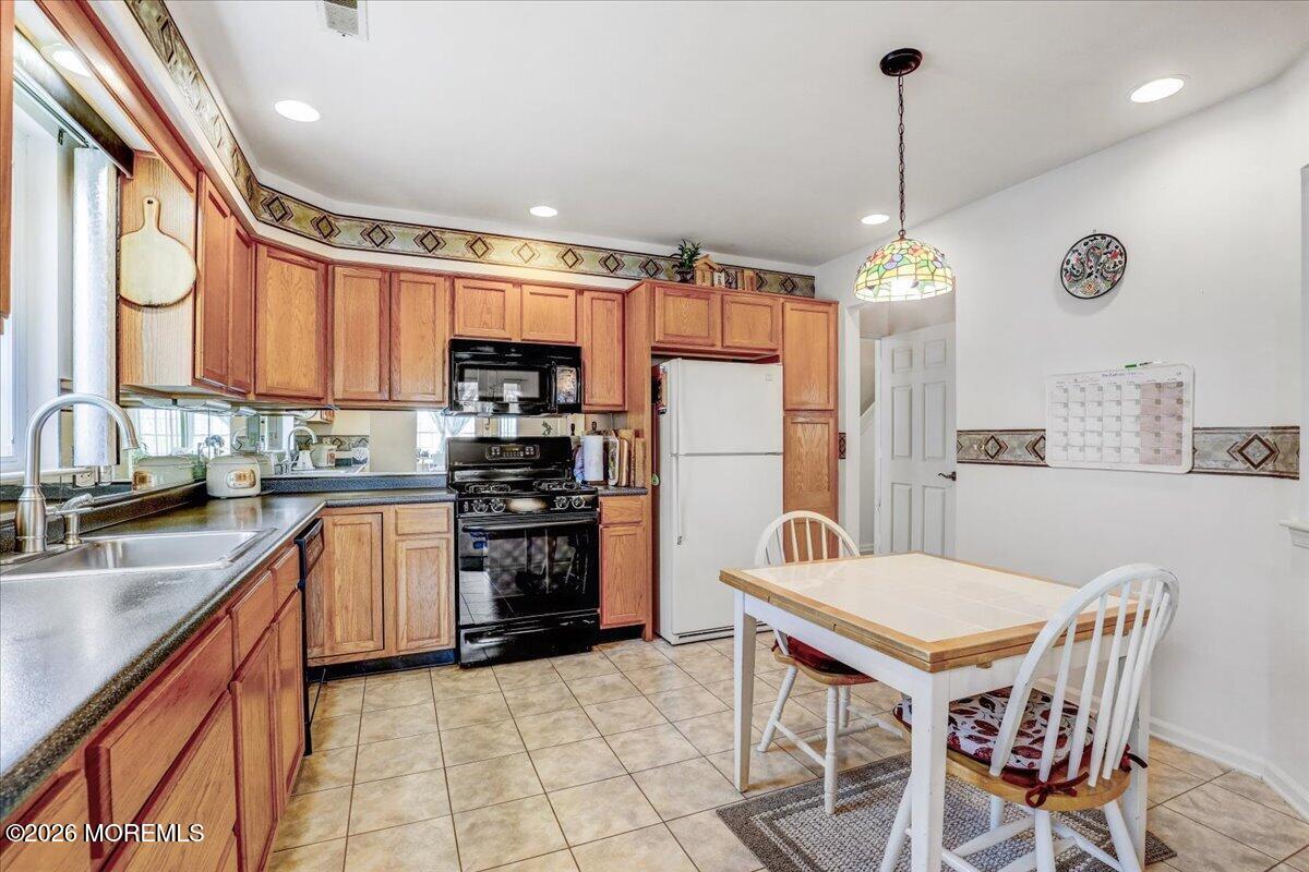 24 Merion Lane Jackson, NJ 08527 - Photo 10 of 45 a kitchen with refrigerator cabinets dining table and chairs