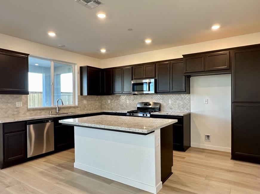 611 Willow Bend Lathrop, CA 95330 - Photo 3 of 11 a kitchen with stainless steel appliances granite countertop a sink stove and refrigerator