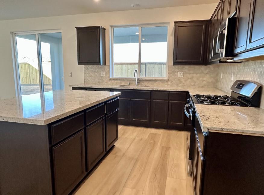 611 Willow Bend Lathrop, CA 95330 - Photo 4 of 11 a kitchen with a sink stove and microwave